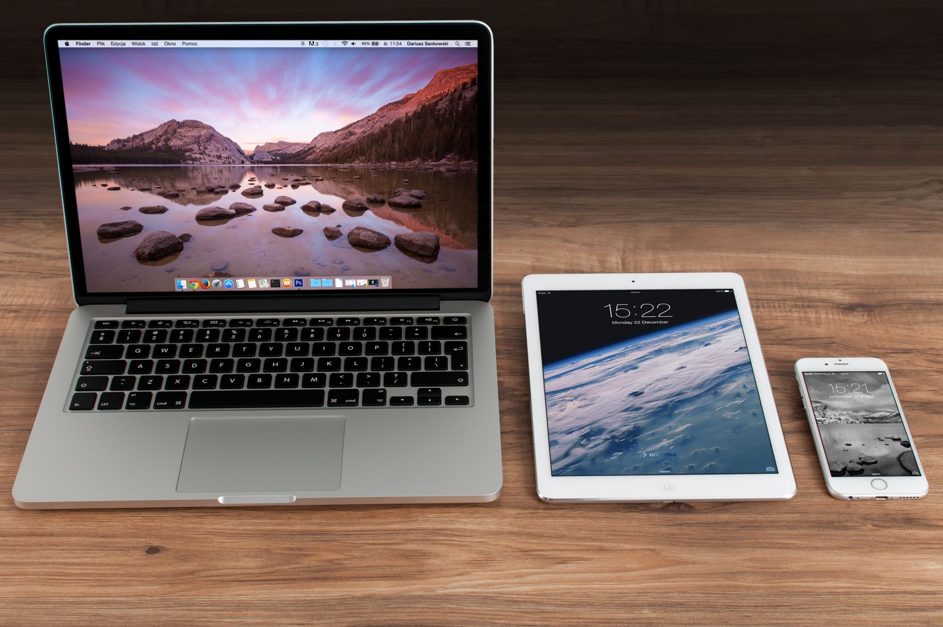 MacBook, iPad, and iPhone on a wooden desk illustrating mobile content parity across devices
