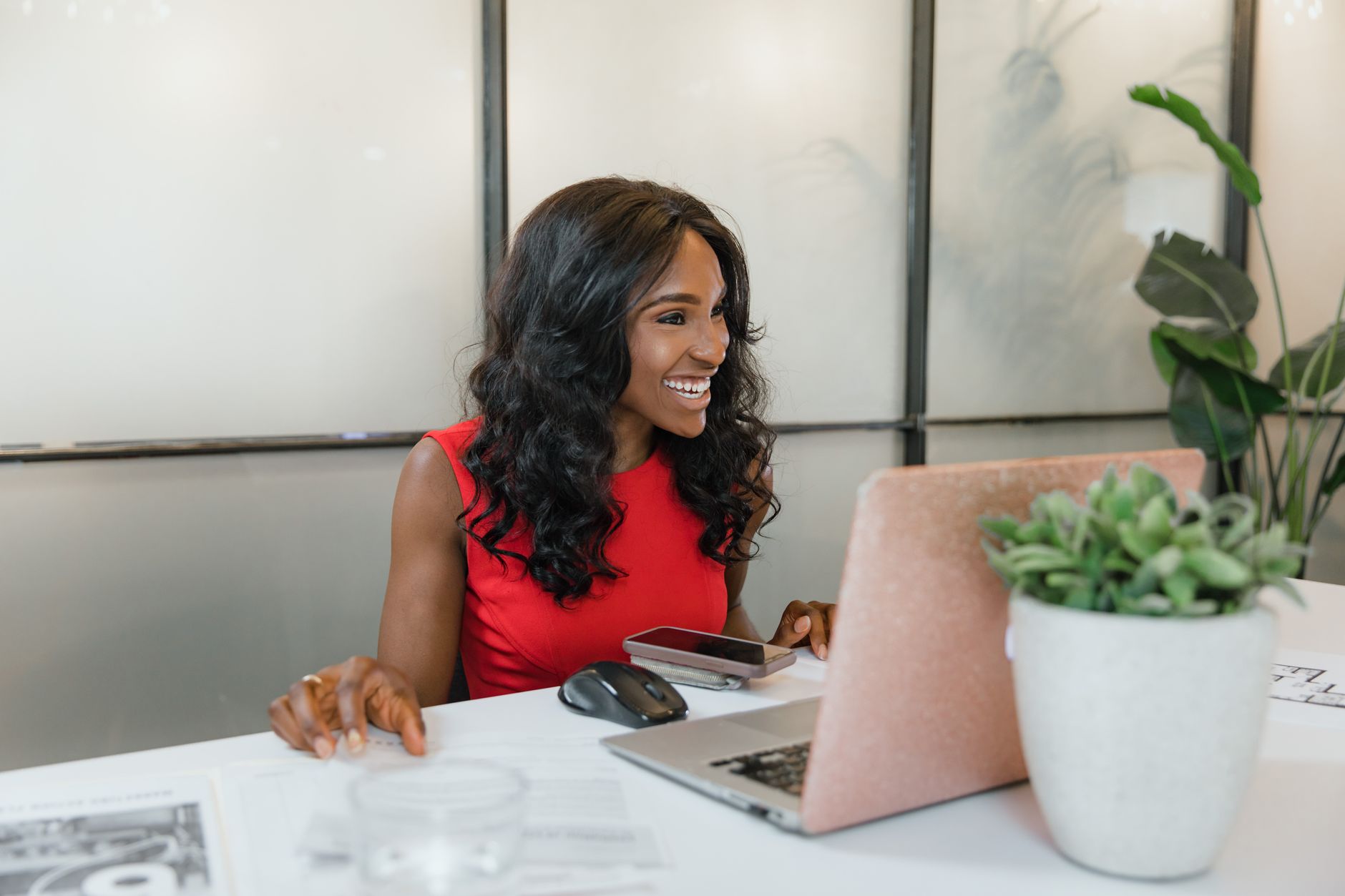 Professional small business owner smiling at her laptop, optimising her WordPress website pages for SEO