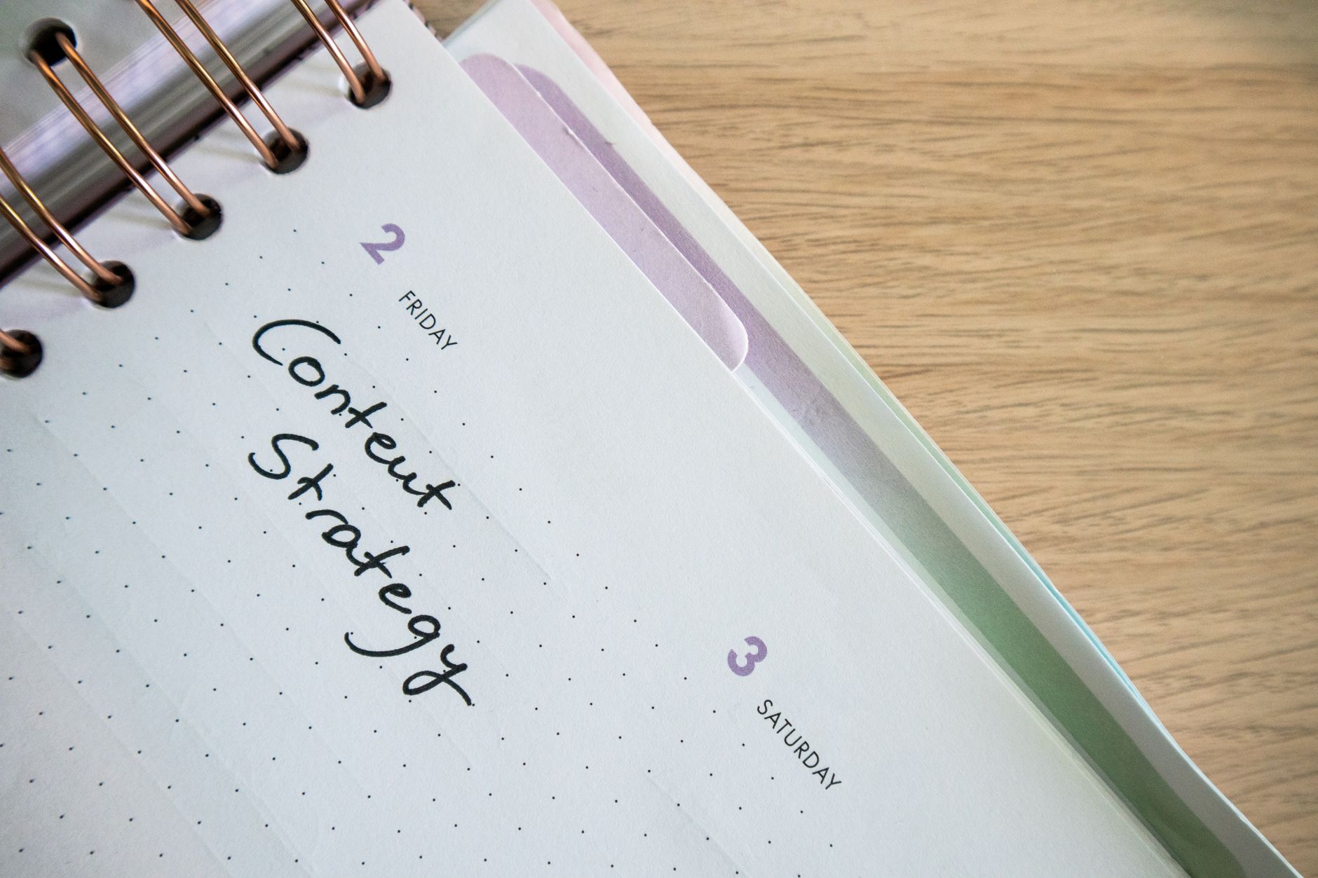 Notebook open to a day planner page with Content Strategy handwritten, representing local SEO content planning