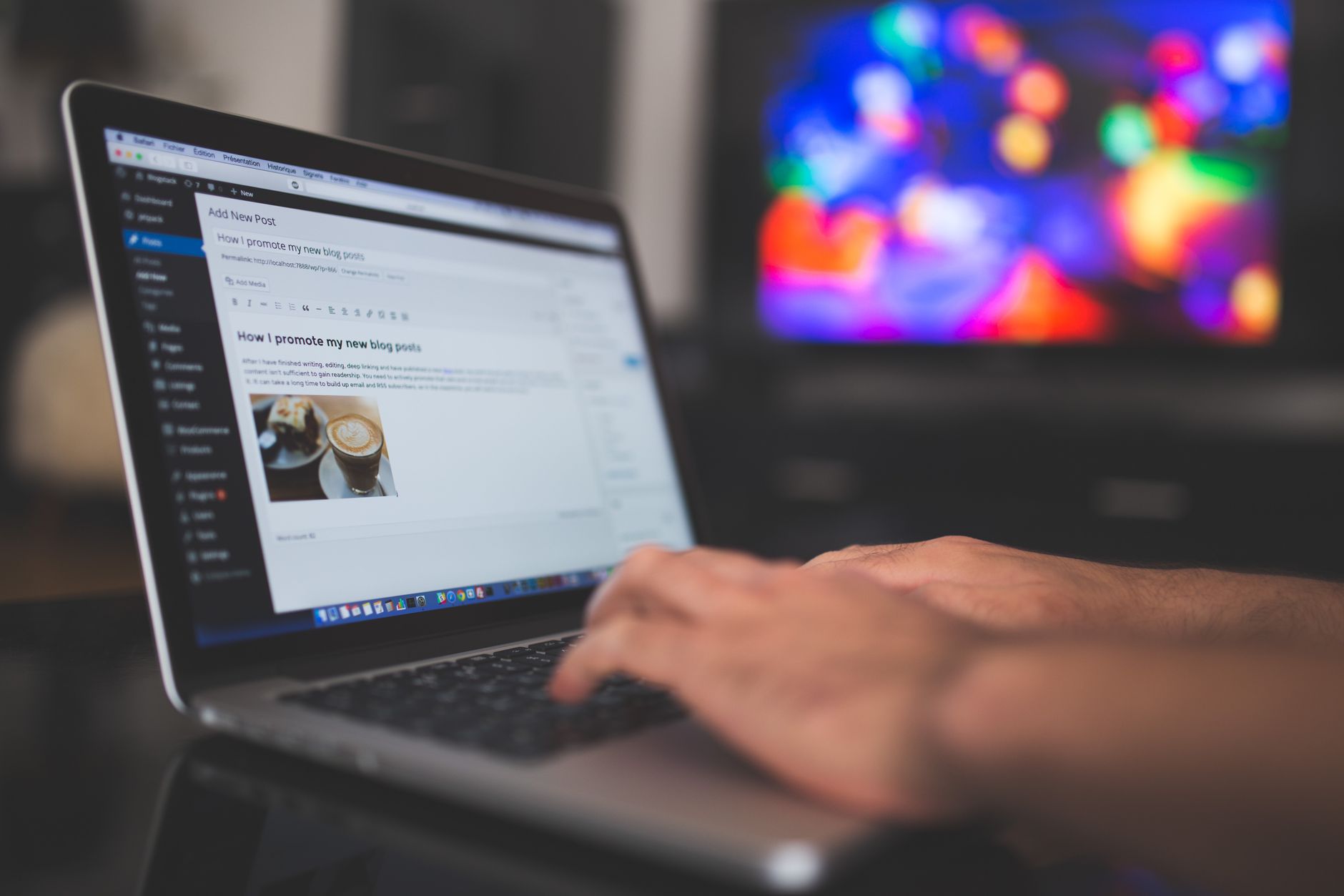 Hands typing on a laptop showing a WordPress blog post editor on screen, representing content formatting for SEO and search intent.