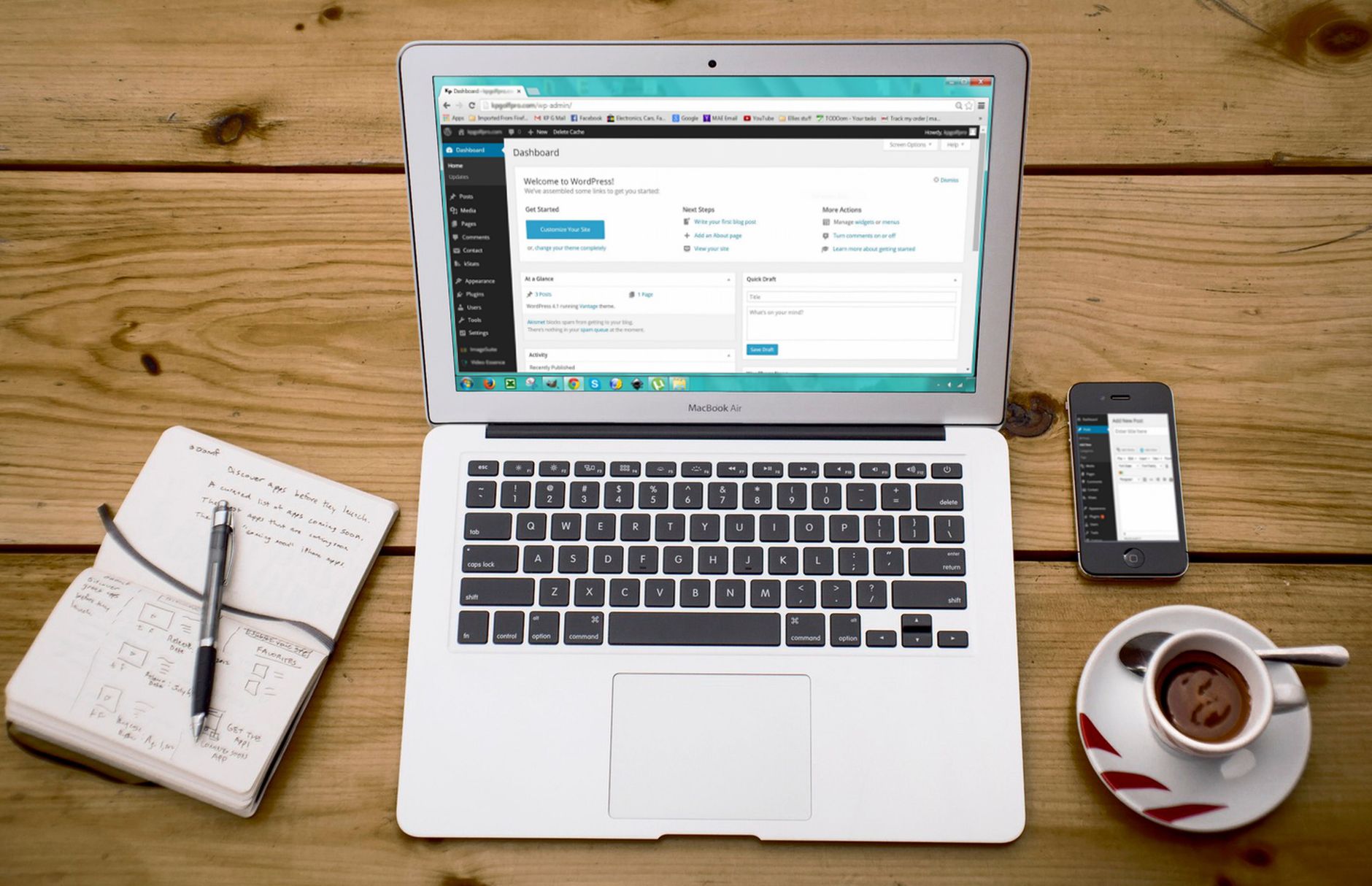 Laptop showing the WordPress dashboard on a wooden desk beside a notebook and coffee, representing SEO plugin configuration
