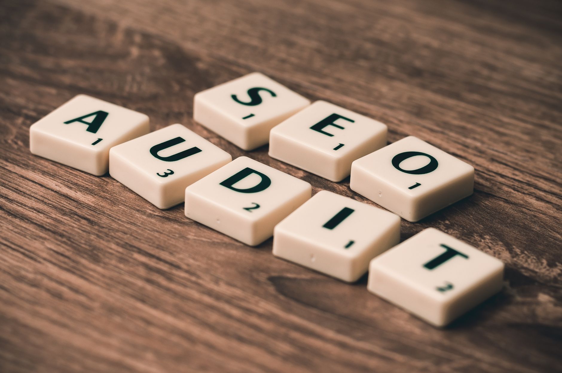 Scrabble tiles spelling SEO Audit on a wooden surface, representing a WordPress SEO setup checklist