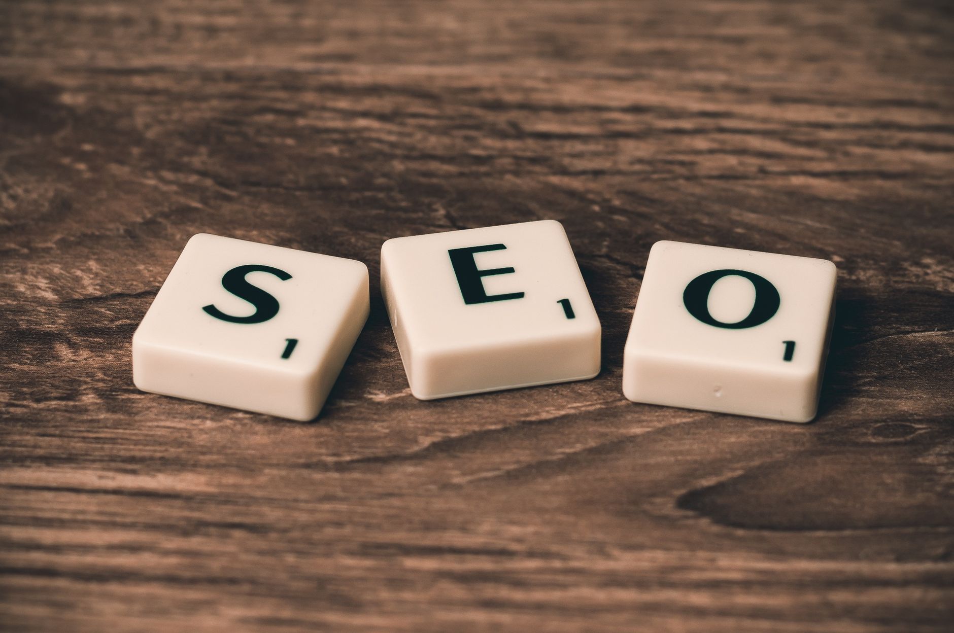 Scrabble tiles spelling SEO on a wooden surface representing search engine optimization