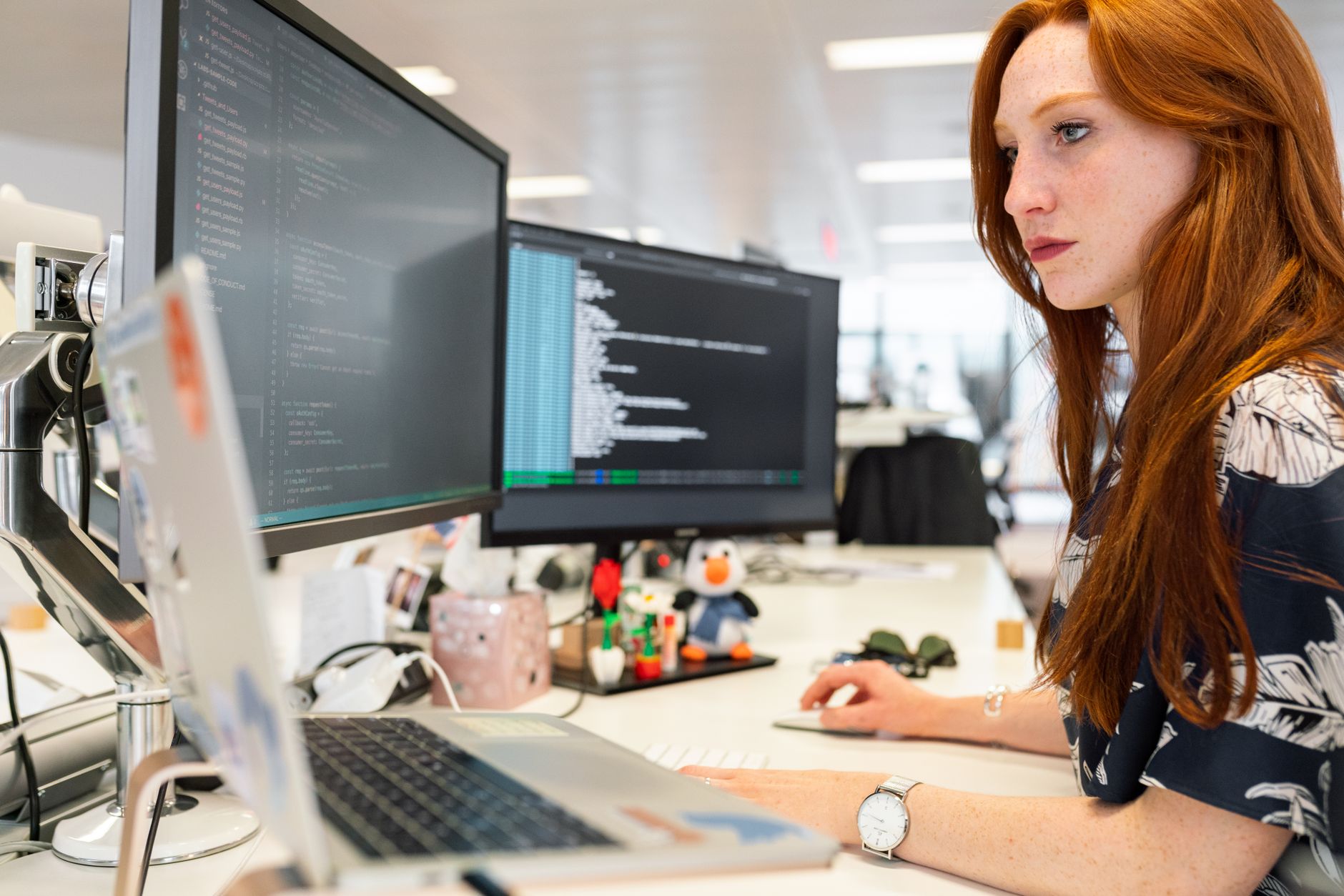Developer reviewing website code on dual monitors to identify and fix technical SEO issues