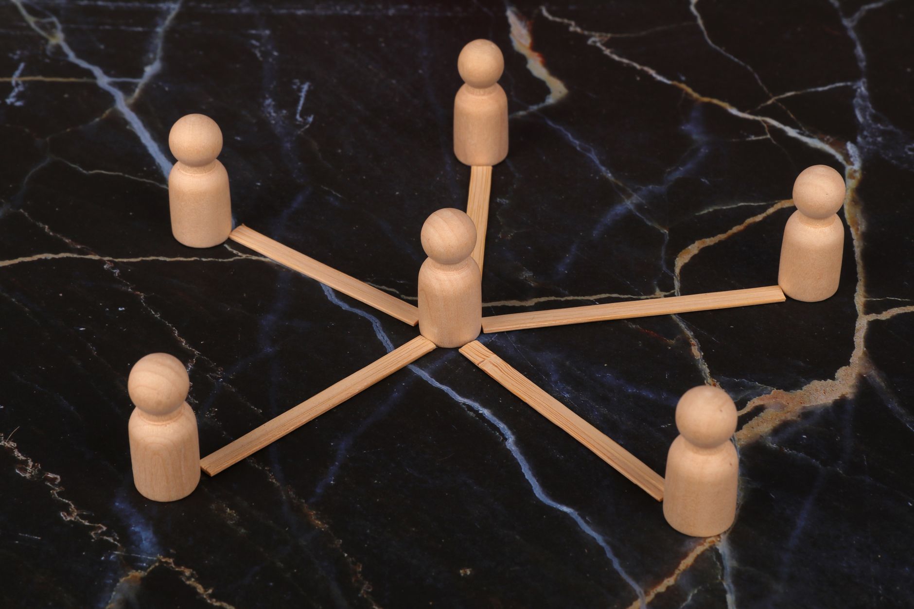 Wooden figures arranged in a hub-and-spoke network pattern, representing internal linking structure for SEO