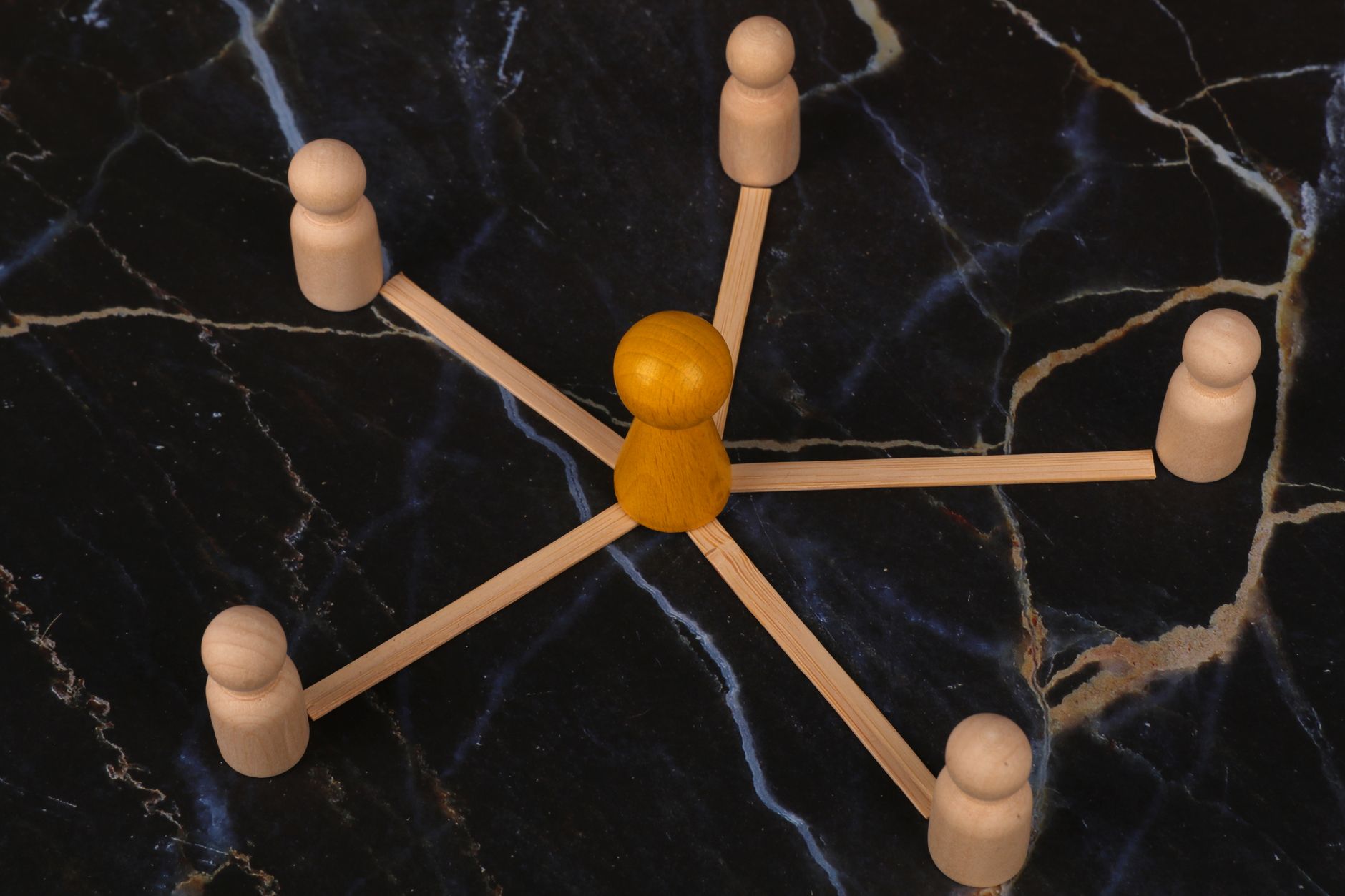 Wooden figures connected in a hub-and-spoke network pattern symbolizing internal linking structure
