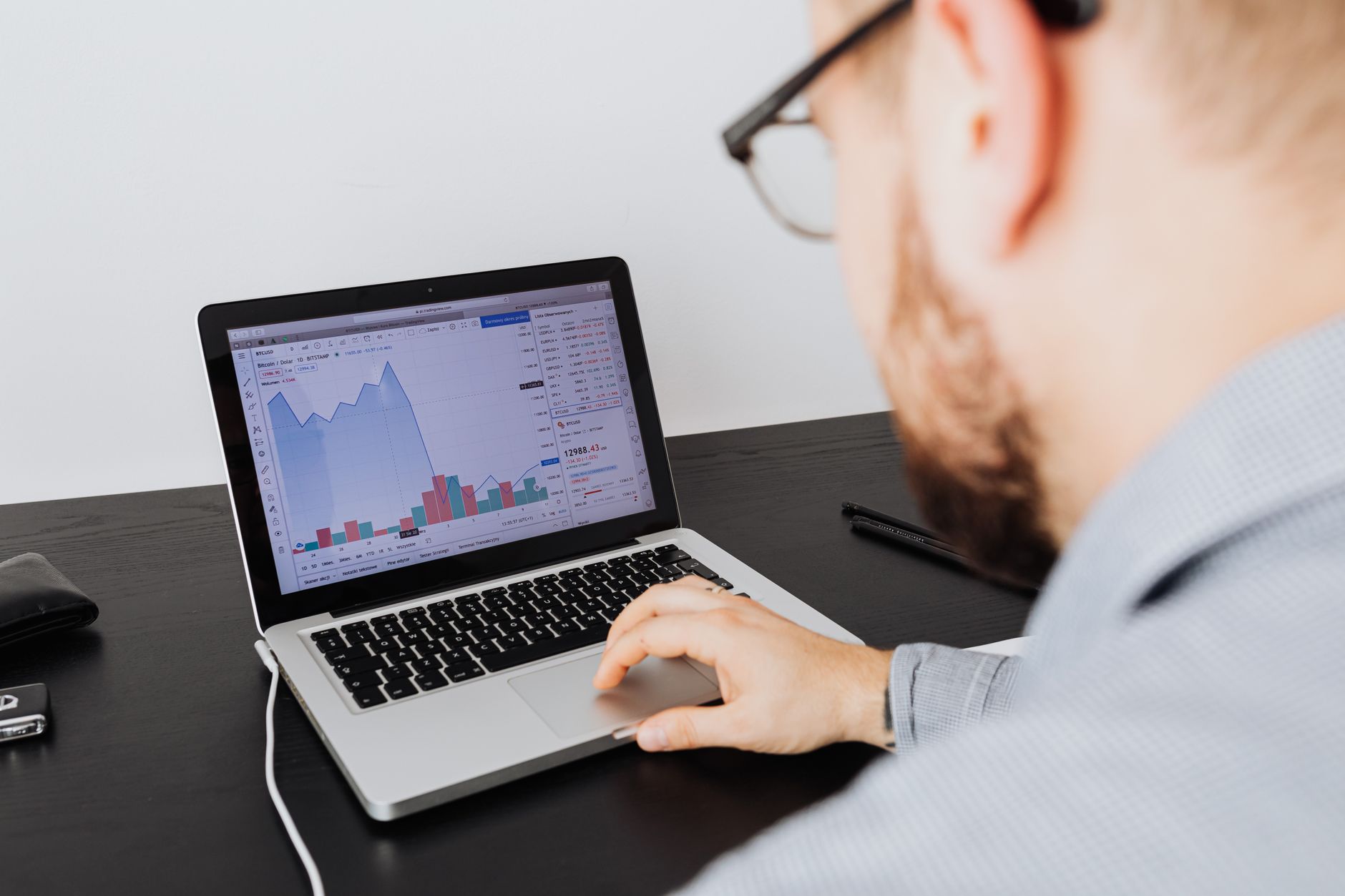 Man with glasses analyzing website traffic and performance data on a laptop, representing traditional SEO strategy and content analysis