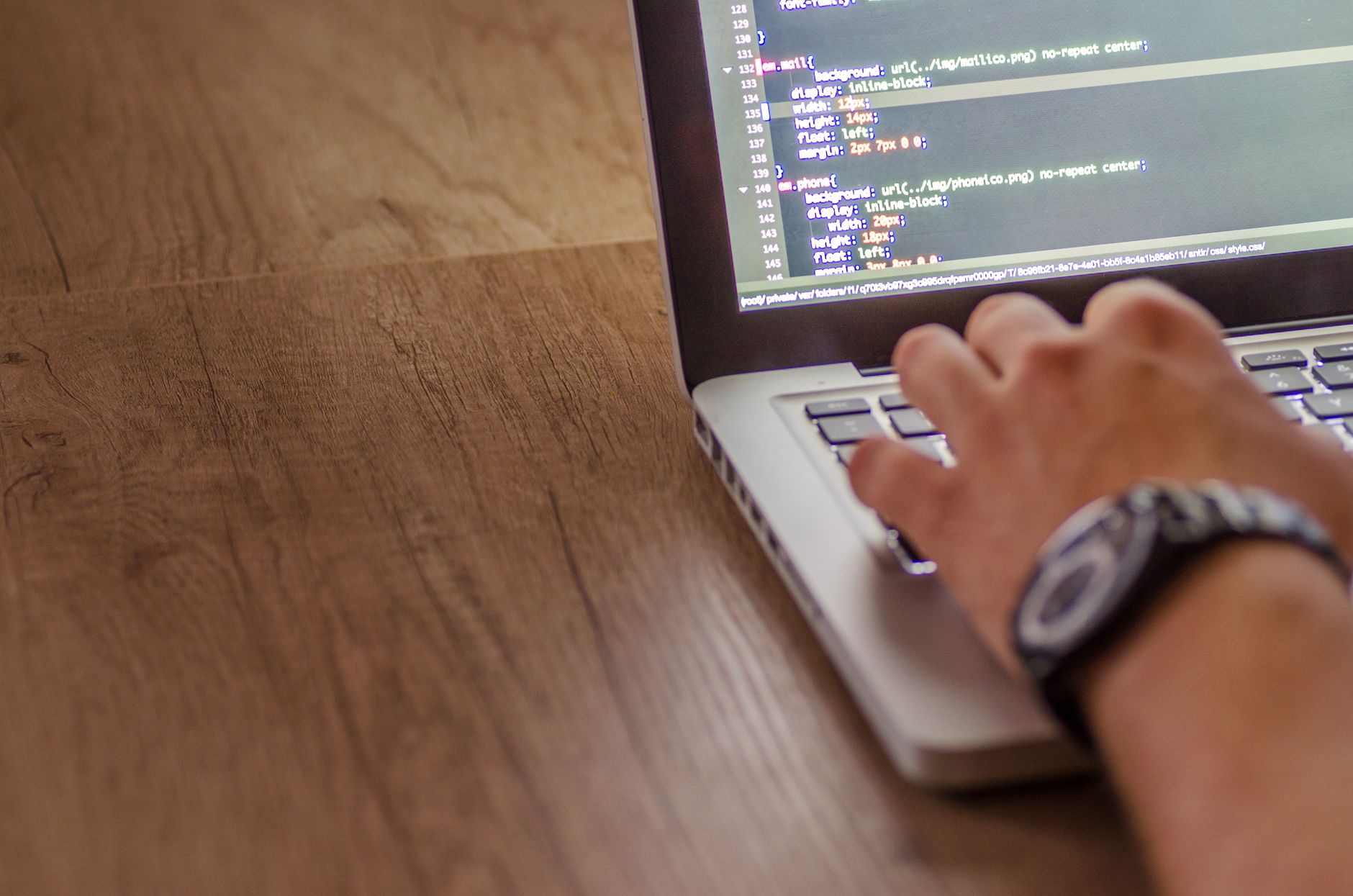 Developer's hand typing code on a laptop, representing website speed and performance optimisation