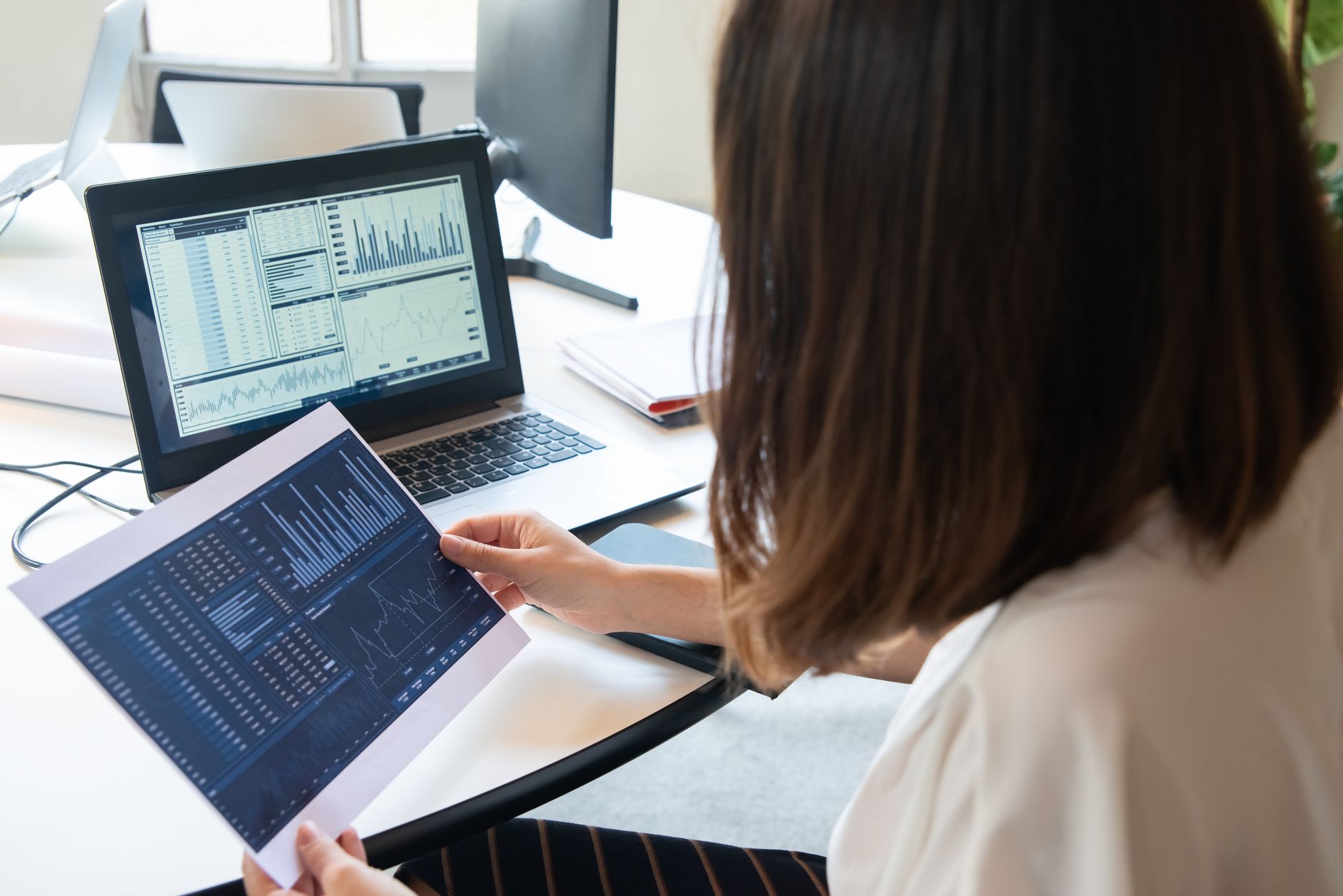 Professional woman reviewing website analytics charts on a laptop screen for SEO performance tracking