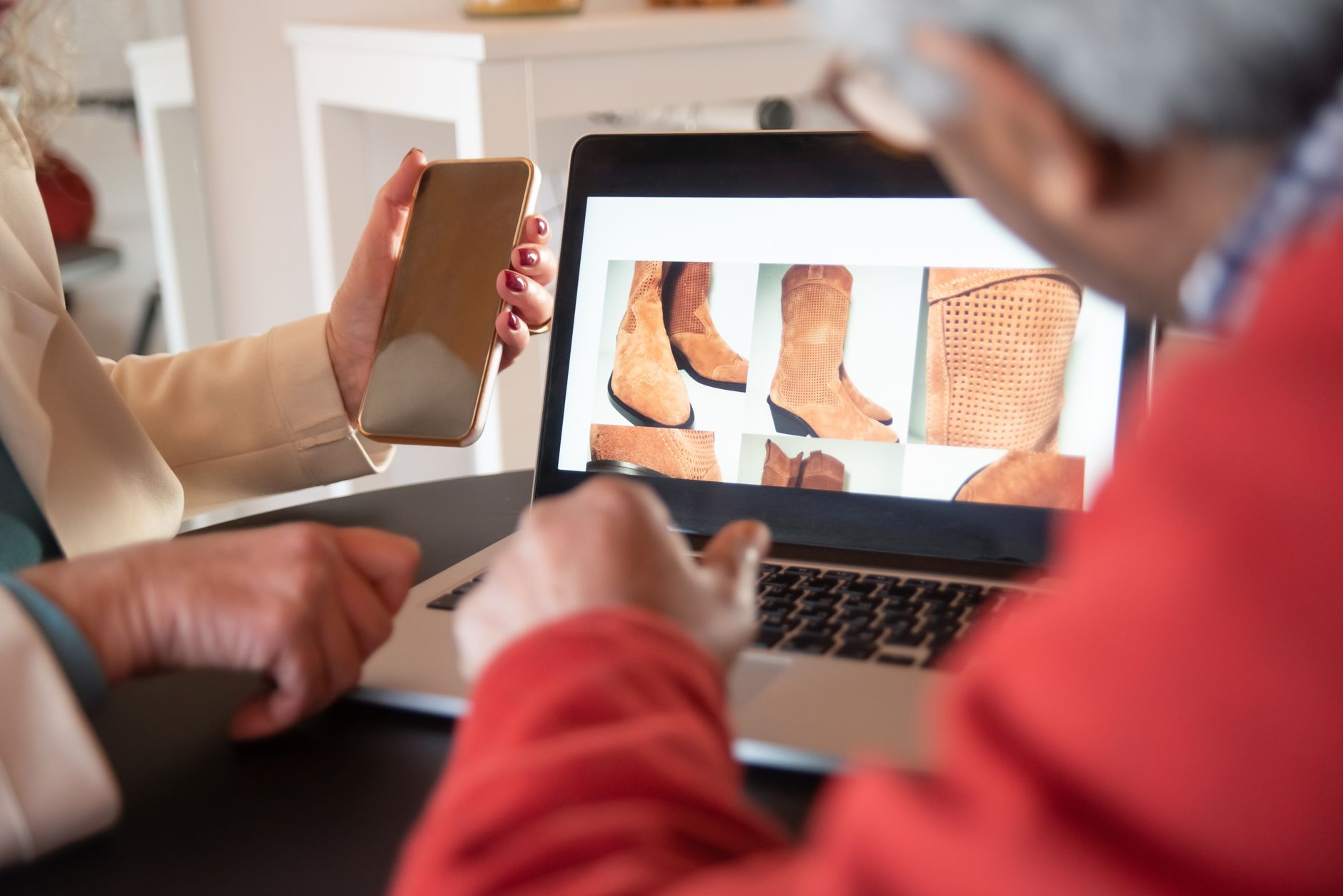Two people browsing an ecommerce product category page on a laptop and smartphone