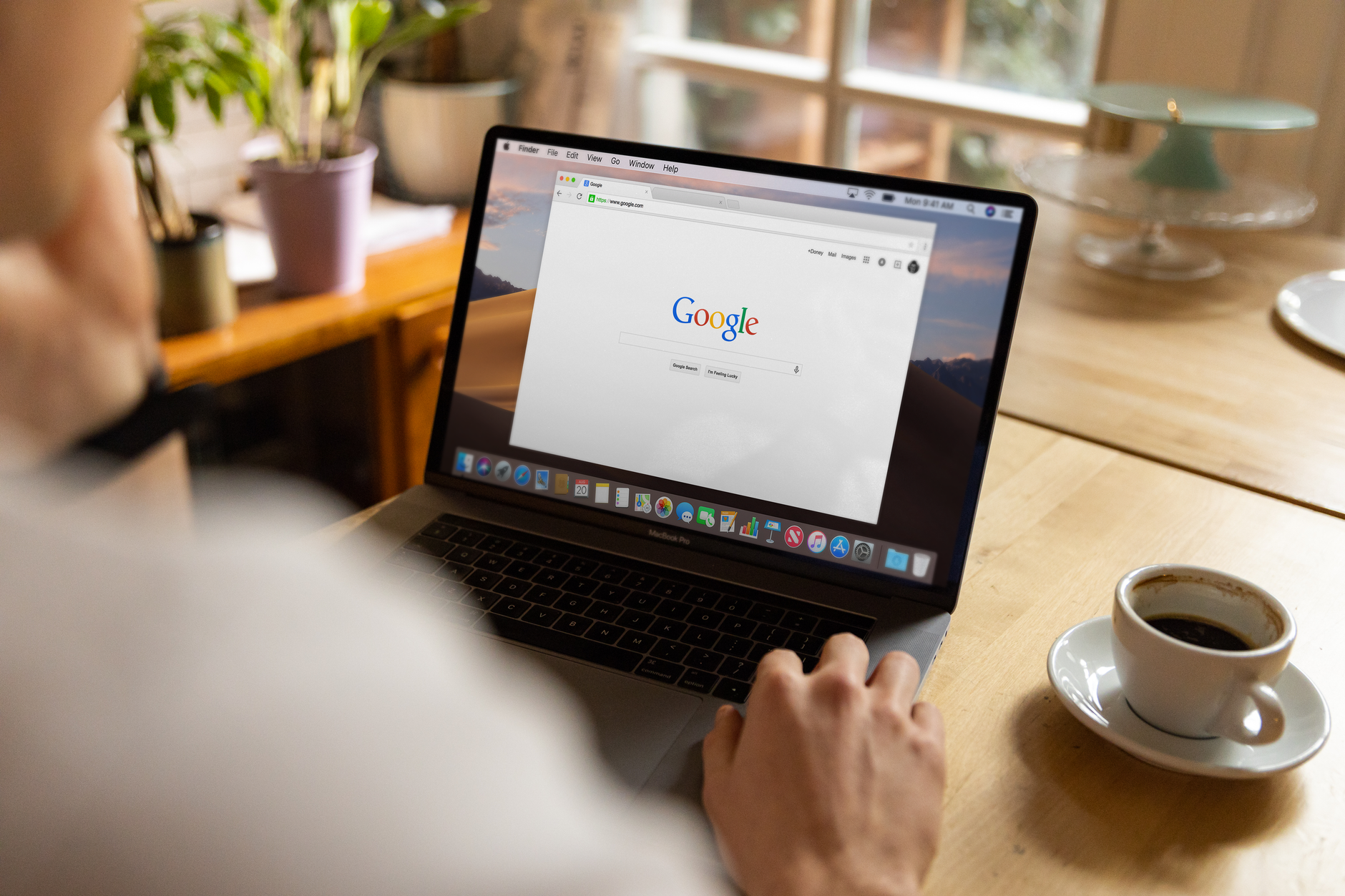 Person browsing Google on a laptop at a wooden desk with coffee, representing WordPress Google SEO setup