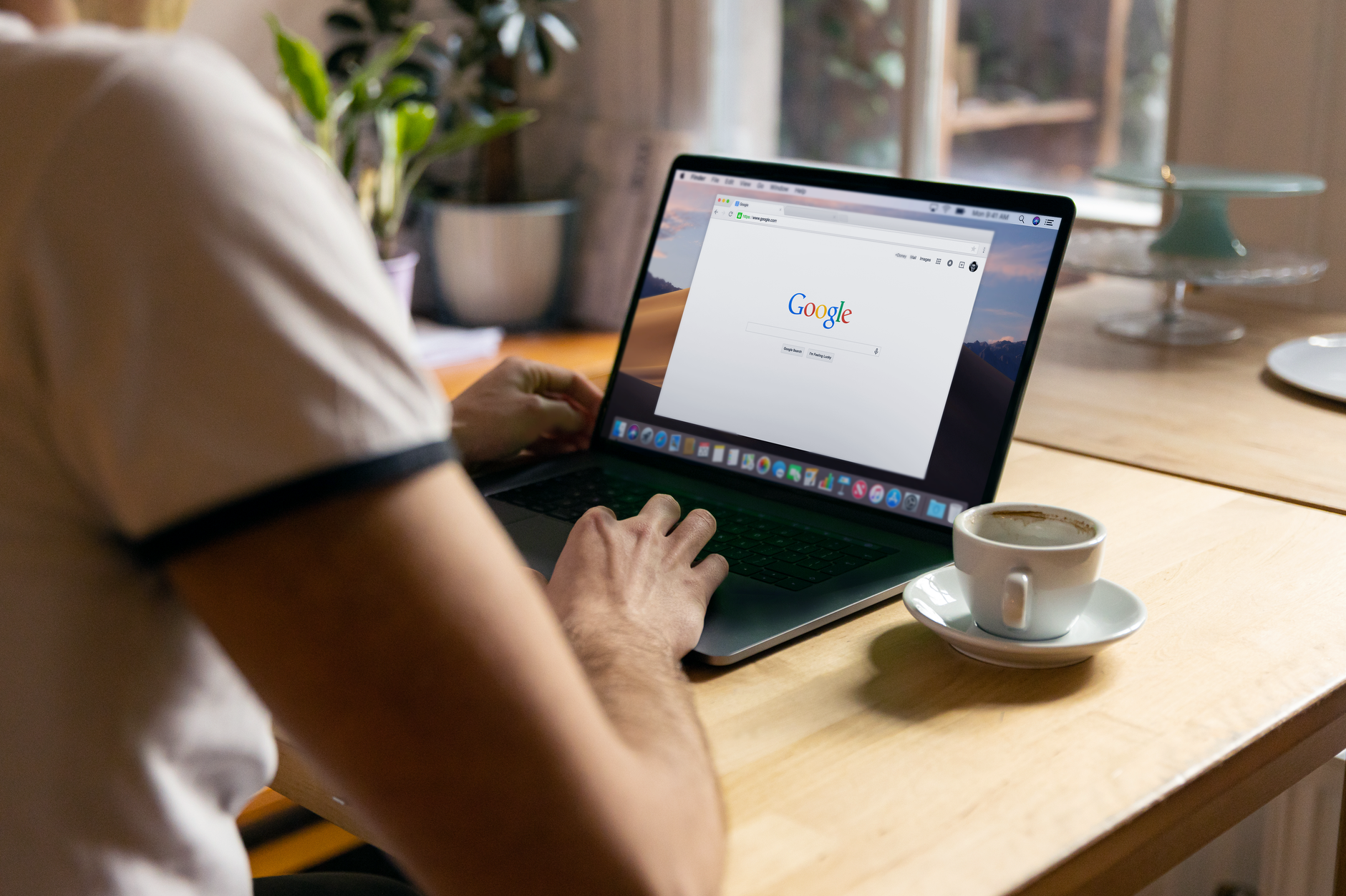 Person reviewing Google search data on a laptop at a desk with a coffee cup, representing Search Console analysis