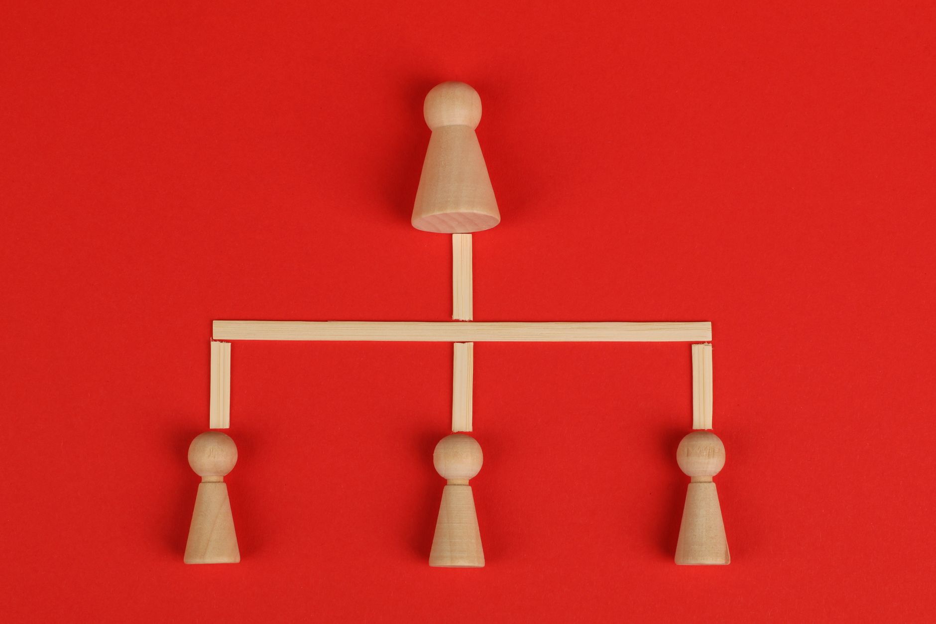 Wooden figures arranged in a hierarchical structure on a red background, representing internal link hierarchy and site architecture for SEO