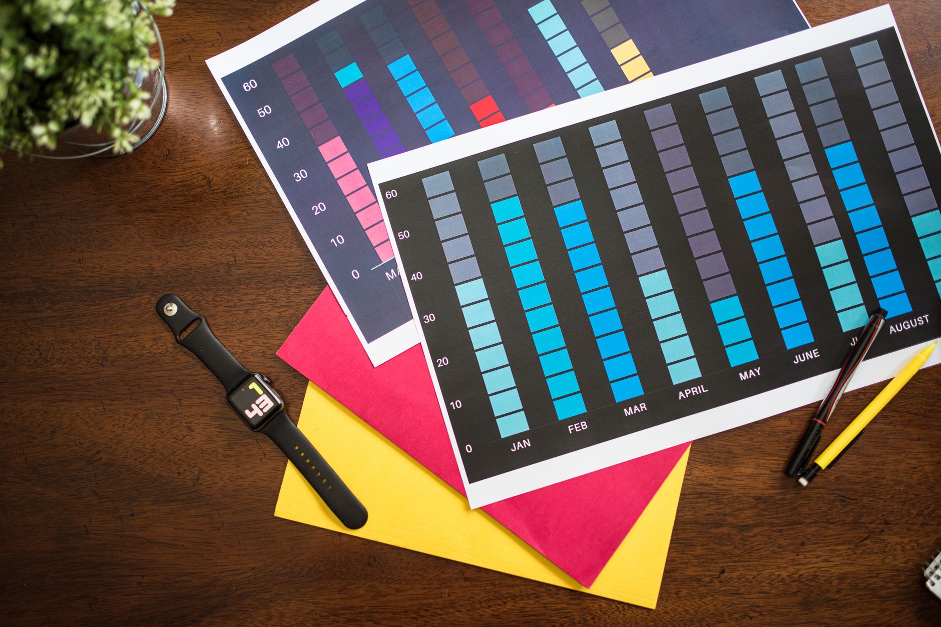 Printed monthly bar charts on a desk showing SEO performance data tracked over time by month