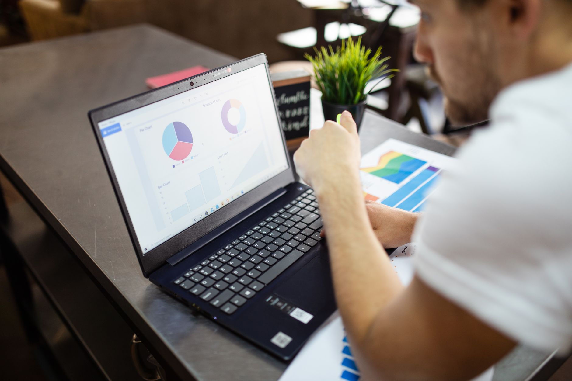 Man reviewing analytics charts on a laptop and tablet, representing tracking SEO changes and measuring improvements over time