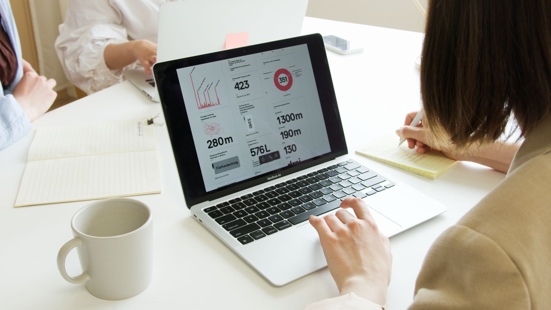 Person reviewing website analytics dashboard on a laptop during a business meeting