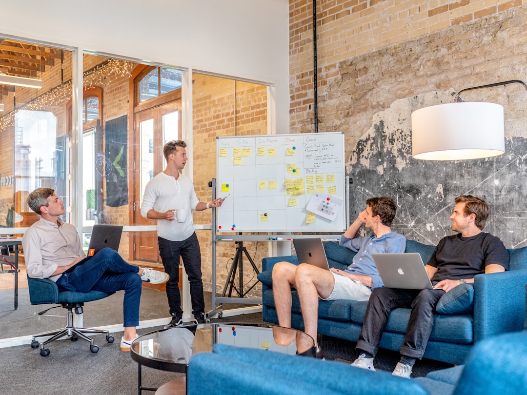 Marketing team reviewing link building strategy on whiteboard in modern office — Photo by Charles Deluvio