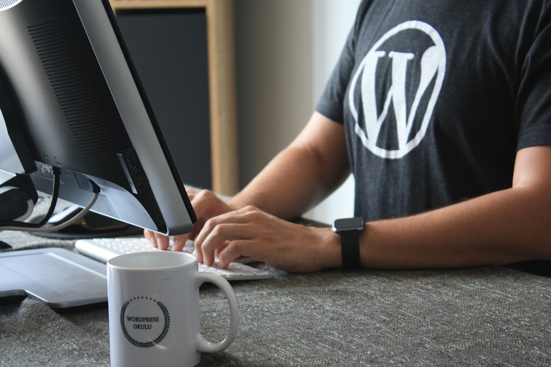 Person wearing a WordPress t-shirt working at a desktop computer, representing WordPress SEO for beginners