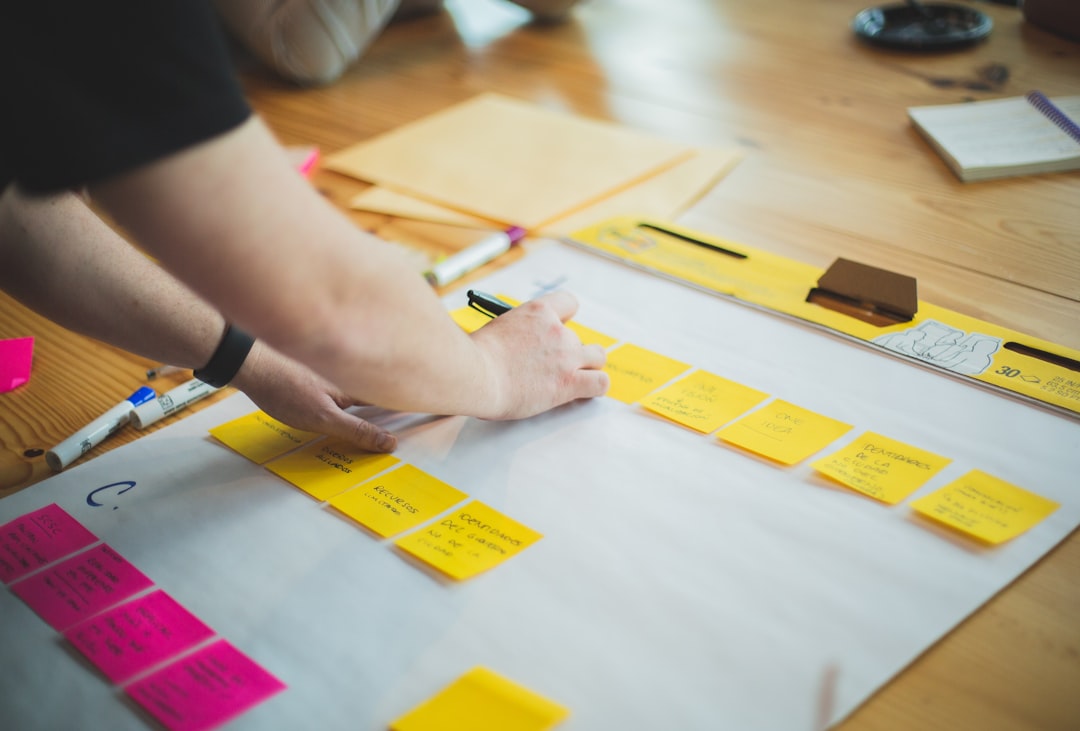 Person mapping out keyword strategy on sticky notes and paper, representing keyword research planning