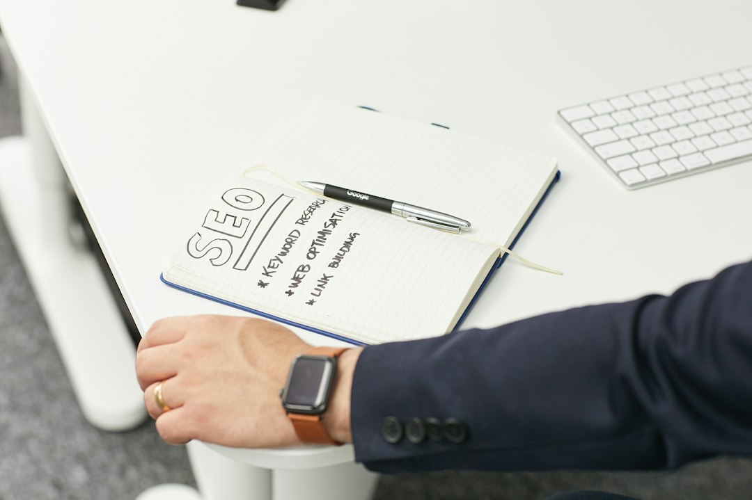 Person writing an SEO checklist in a notebook at a desk, planning WordPress SEO priorities