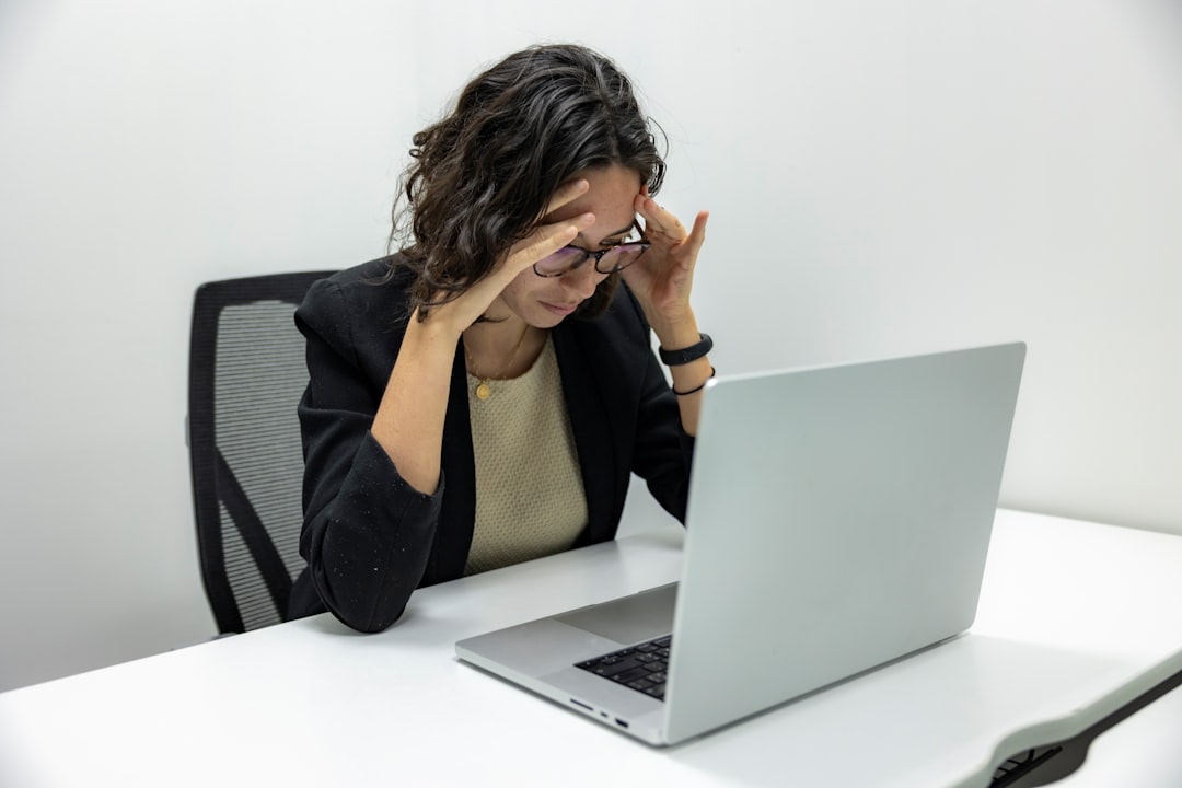 Stressed woman holding her head while looking at a laptop — representing the confusion caused by conflicting WordPress SEO tutorial advice