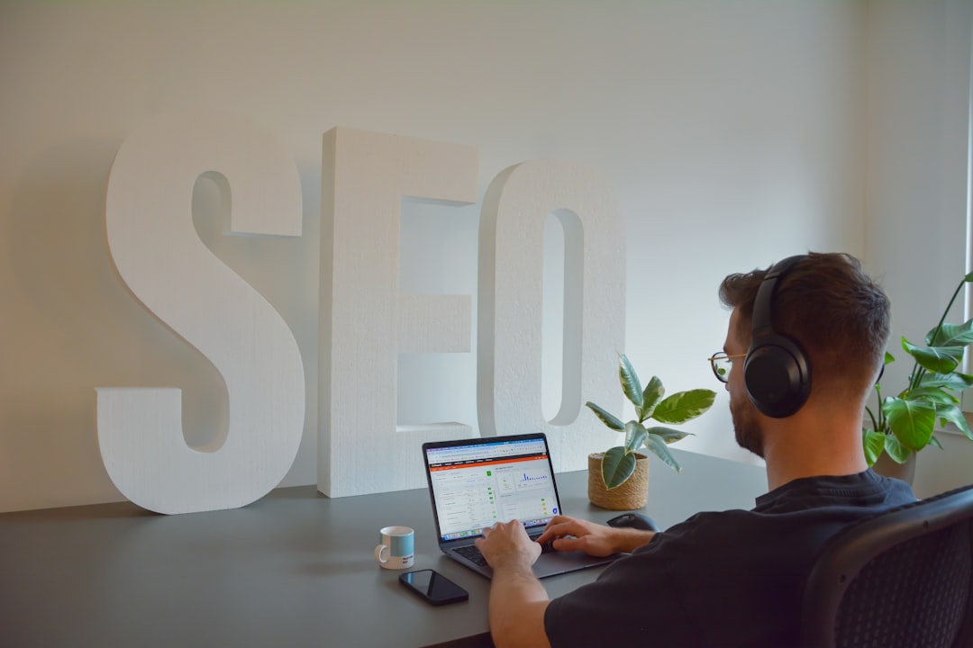 SEO professional working at a desk with large SEO letters in the background