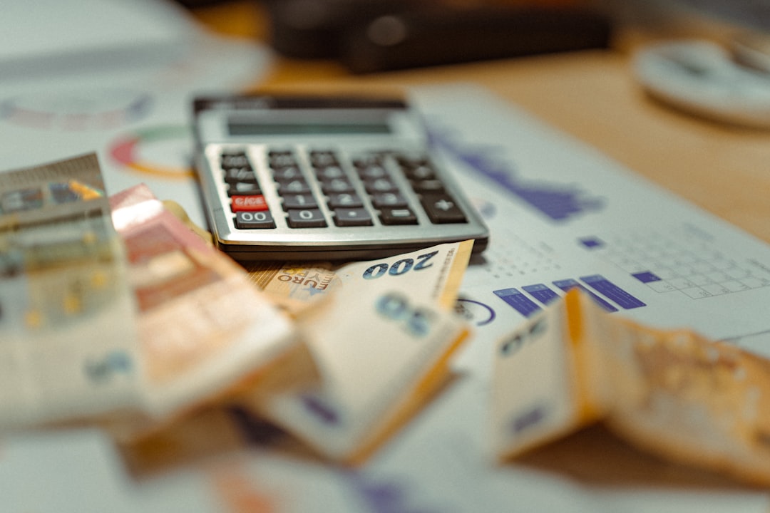 Calculator sitting on top of banknotes and financial reports representing link building cost analysis